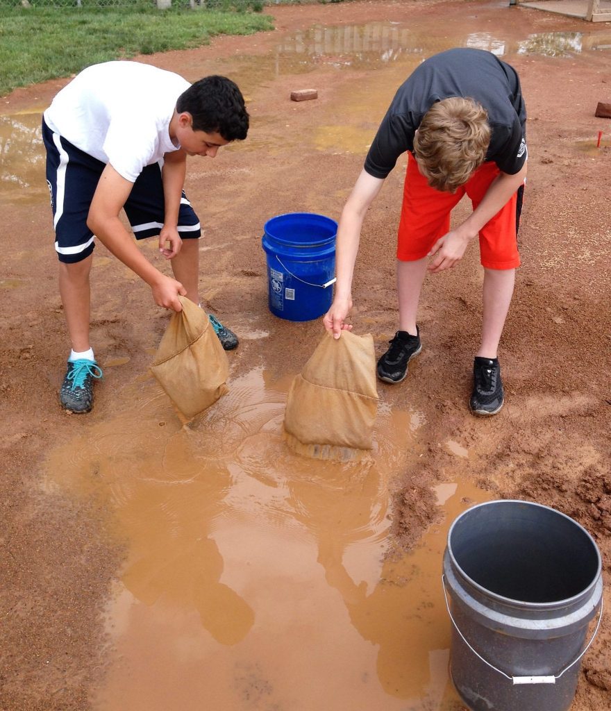 two kids getting water off field 