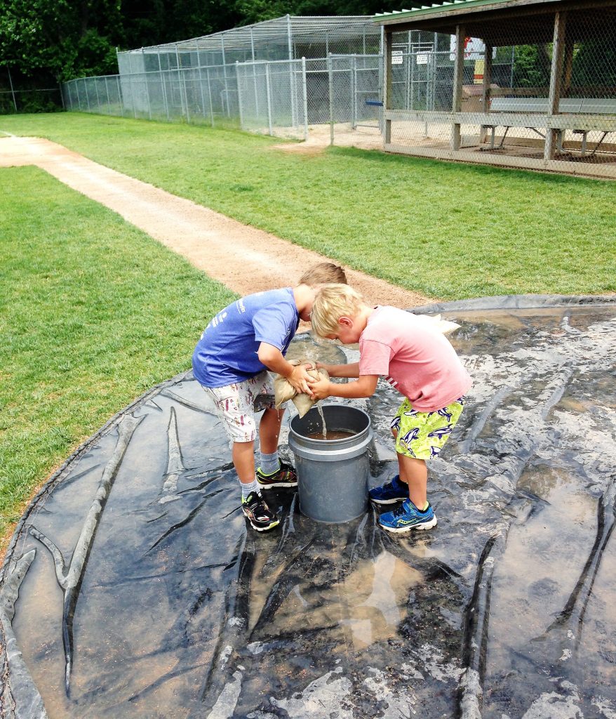two kids playing in a bucket of water