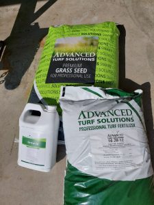 seed bag, fertilizer bag, and fertilizer jug on driveway