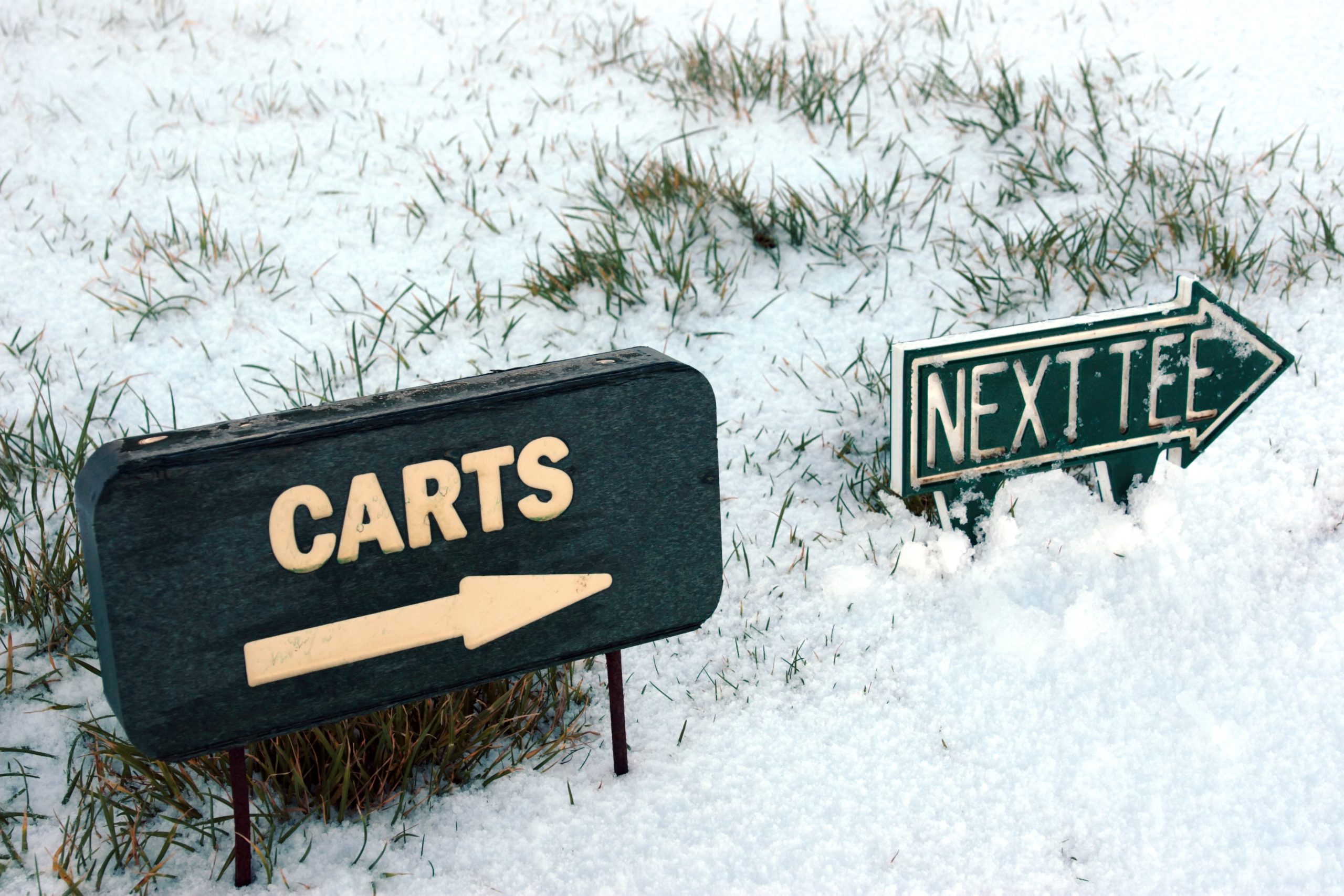 carts and next tee sign on a snow covered links golf course in ireland in snowy winter weather