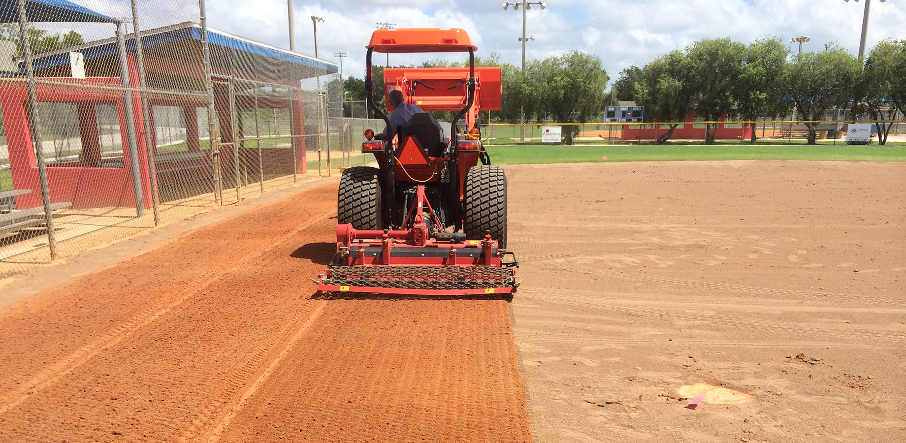 preparing the infield by leveling the dirt