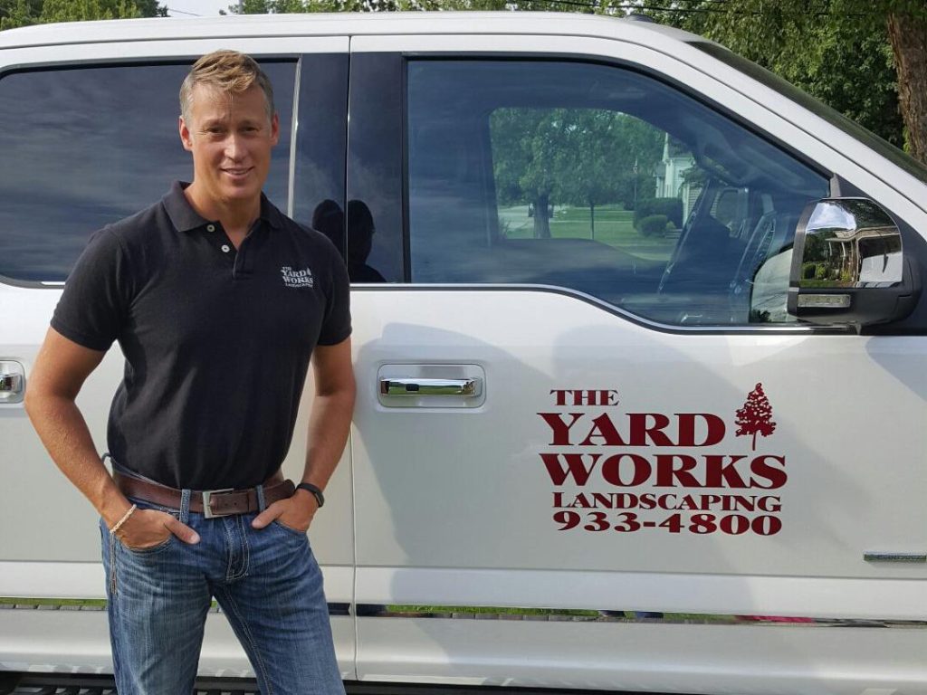 Chad Haney standing in front of The Yard Works Landscaping truck