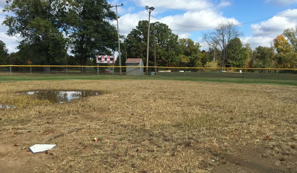 home plate view of baseball field with puddles and grass