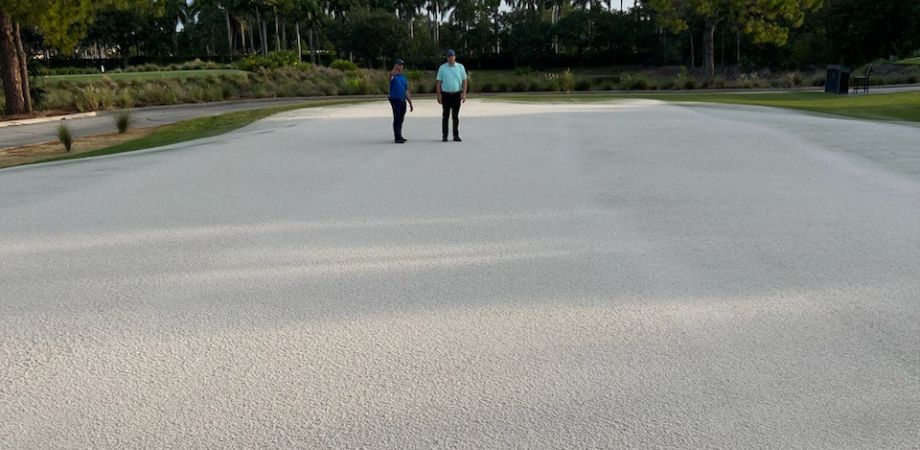 Two men looking at topdressed area on golf course
