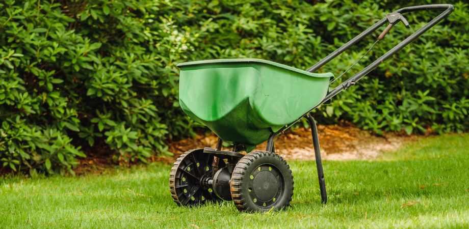 Broadcast spreader machine on lawn